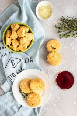 Beyaz seramik tabakta peynir ve kekik ile tuzlu çörekler veya kurabiyeler. Açık gri beton arka plan. 