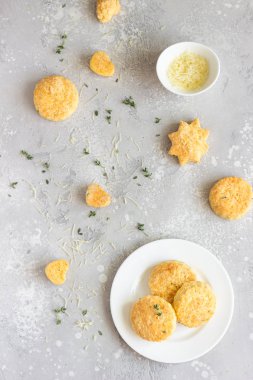 Beyaz seramik tabakta peynir ve kekik ile tuzlu çörekler veya kurabiyeler. Açık gri beton arka plan. 