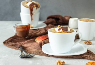 Beyaz bir seramik kupa krem şanti, karamel sos ve ceviz ile Havuç veya kabak kupa cupcake. Rahat sonbahar veya kış kahvaltısı. Sağlıklı tatlı. 