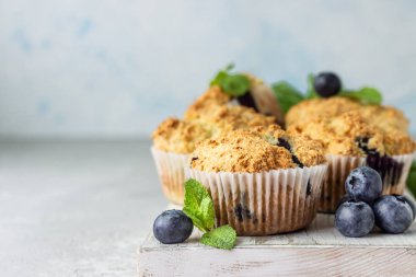 Açık gri taş arka plan taze çilek ve nane yaprakları ile yaban mersini kekler. Kopyalama alanı.