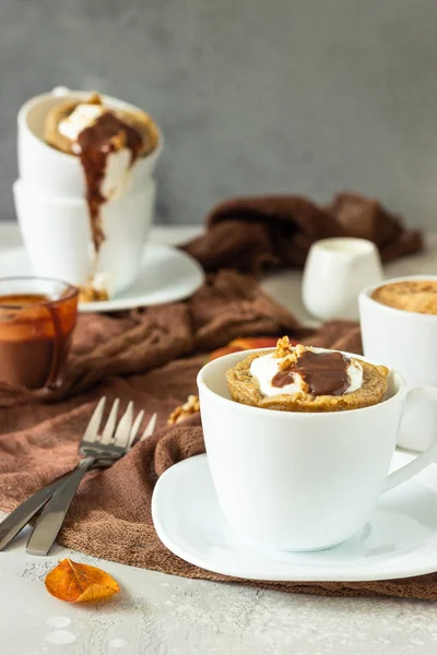 Beyaz bir seramik kupa krem şanti, karamel sos ve ceviz ile Havuç veya kabak kupa cupcake. Rahat sonbahar veya kış kahvaltısı. Sağlıklı tatlı. 