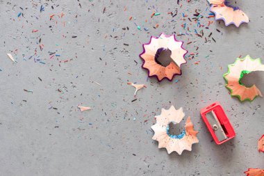 Gri taş arka plan üzerinde renkli kalemler ve taleşler. Kopyalama alanı.