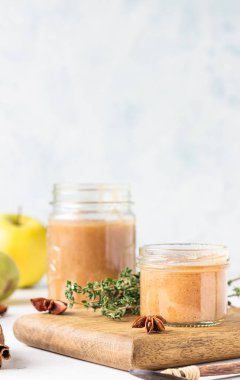 Cam kavanozda baharatlı armut reçeli, taze armut, baharat (tarçın ve anason) ve kekik.