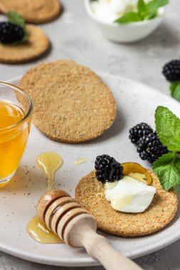 Krem peynir, böğürtlen, üzüm, nane ve bal ile ince gevrek kepekli kraker. 