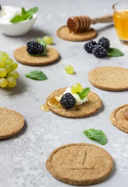 Krem peynir, böğürtlen, üzüm, nane ve bal ile ince gevrek kepekli kraker. 