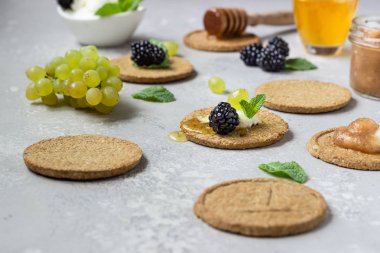 Krem peynir, böğürtlen, üzüm, nane ve bal ile ince gevrek kepekli kraker. 