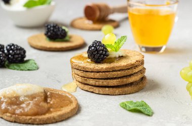 Krem peynir, böğürtlen, üzüm, nane ve bal ile ince gevrek kepekli kraker. 