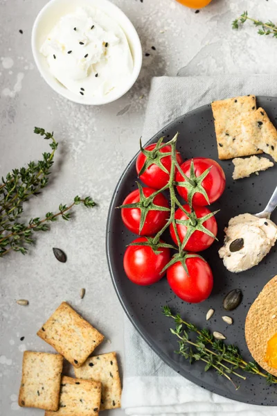 Cracker Integrali Croccanti Sottili Con Crema Formaggio Pomodori Piatto Nero — Foto Stock