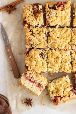 Kırmızı meyve reçeli, baharat ve ufalanmış ile Elma pasta barlar. Crumble kek. Açık gri arka plan.