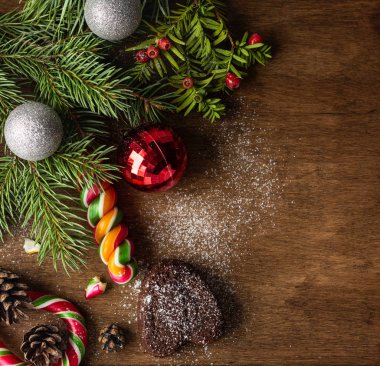 Yeni yıl ağaç dalları, topları ve şekerler ile Noel tebrik kartı. Selamlarınız için yer kopyalayın. Şenlikli arka plan.