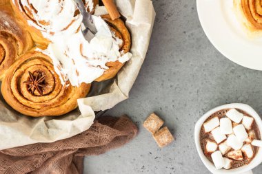 Tarçın rulo (Cinnabon) krem peynir krema ile dökme demir tavada pişirilir. Kanelbullens dag.
