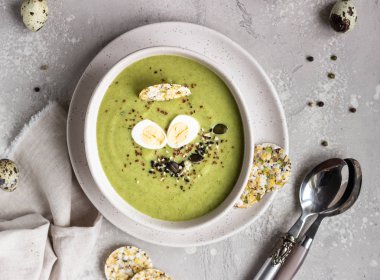 Tohum karışımı ile Detoks brokoli yeşil krema çorbası, bıldırcın yumurta sıyrık ve açık gri taş arka plan üzerinde kase kraker. Üst te. Sağlıklı gıda kavramı.