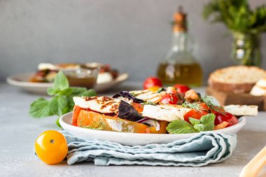 Domates, fırında biber ve ızgara haloumi peynirli soğan salatası. Keto diyeti, sağlıklı yiyecekler.