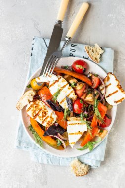 Domates, fırında biber ve ızgara haloumi peynirli soğan salatası. Keto diyeti, sağlıklı yiyecekler.