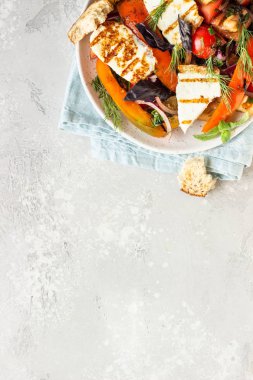 Domates, fırında biber ve ızgara haloumi peynirli soğan salatası. Keto diyeti, sağlıklı yiyecekler.