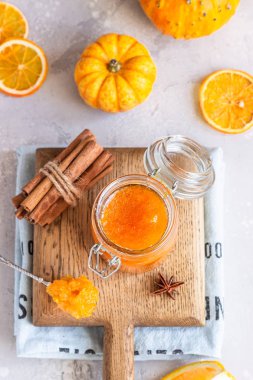 Açık gri arkaplanda portakal ve baharatlarla (tarçın ve anason) kabak konfeksiyonu (reçel veya reçel).