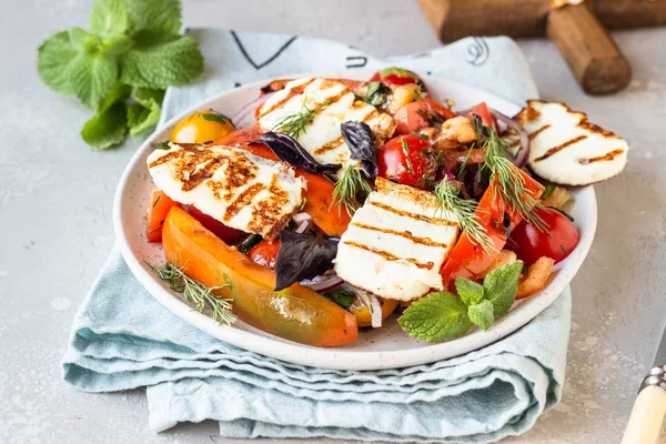 Domates, fırında biber ve ızgara haloumi peynirli soğan salatası. Keto diyeti, sağlıklı yiyecekler.