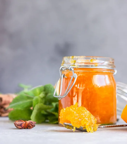 ガラス瓶のオレンジジャムやマーマレード 新鮮な乾燥オレンジフルーツスライス ミントとスパイスライトグレーの背景 — ストック写真