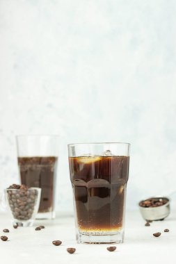 Espresso tonik, tonik, kahve ve buz küplü yaz içeceği, açık gri arka plan. Moda kahvesi..