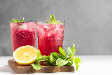 Limonlu pembe limonata ve açık gri arka planda nane şekeri. Yaz içeceği..