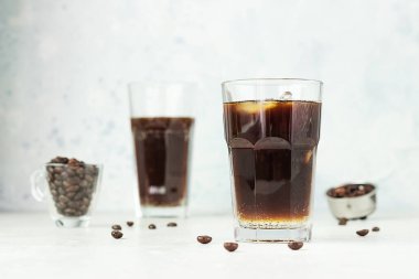 Espresso tonik, tonik, kahve ve buz küplü yaz içeceği, açık gri arka plan. Moda kahvesi..