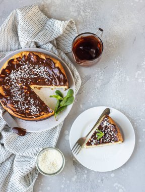 Bir parça ev yapımı, çikolata soslu, hindistan cevizli ve naneli peynirli kek yok. Açık gri arkaplan.