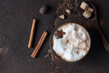 Bir fincan sıcak kakao ya da anason yıldızı ve tarçın çubuklu sıcak çikolata. Sonbahar ya da kış için geleneksel içecek. Karanlık arka plan. Üst görünüm.