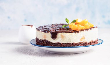 Kremalı pasta, kayısı kaplı fırında peynirli kek yok. Çikolata jöleli, kayısı ve açık arkaplanda nane şekeri..