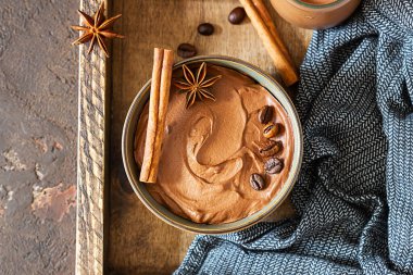 Tahta tepside kahve ve baharatla çikolatalı tatlı. Kırsal tarzda. Baharatlı çikolata ve kahve köpüğü..