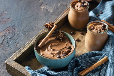 Tahta tepside kahve ve baharatla çikolatalı tatlı. Kırsal tarzda. Baharatlı çikolata ve kahve köpüğü..