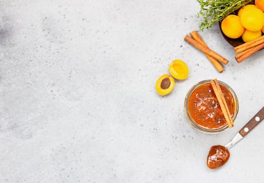 Cam kavanozda kayısı reçeli, taze kayısı, kekik ve tarçın..