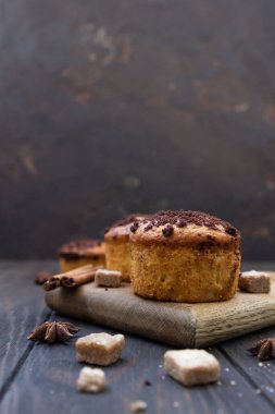 Çikolatalı ve tarçınlı leziz muffinler ve ahşap kesim tahtasında anason yıldızı..