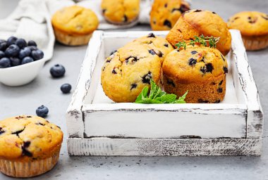 Tahta tepside kekik, nane ve taze böğürtlenli yabanmersinli kek. Gri beton arkaplan.