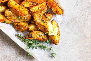 Lezzetli, kekik ve soslu çıtır patatesler paket yiyecek ve hafif beton arka plan için. Sokak yemeği. Üst görünüm.