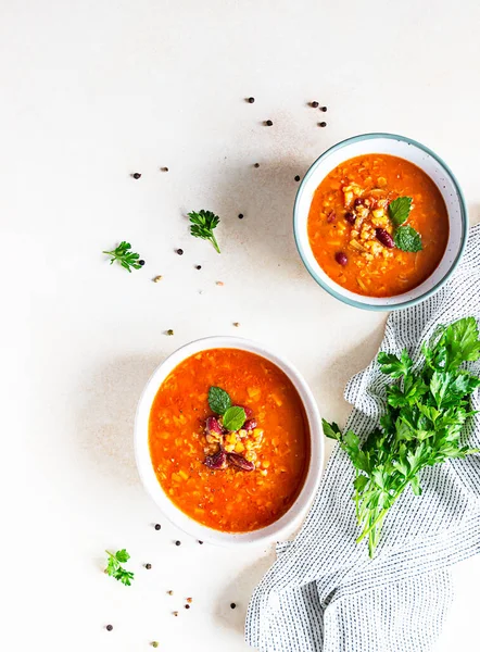 Sıcak ve baharatlı, kalın mercimek ve konserve domates ve kişniş soslu fasulye çorbası. Somut arkaplan, seçici odak.