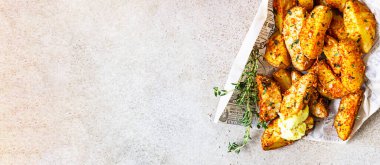 Lezzetli, kekik ve soslu çıtır patatesler paket yiyecek ve hafif beton arka plan için. Sokak Fast food.