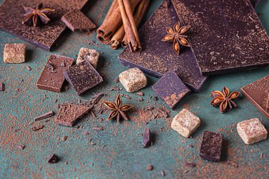 Koyu ve sütlü çikolata parçaları, kakao tozu, tarçın, anason yıldızı ve esmer şeker. Şekerleme dükkanı reklamcılığı ve yemek malzemeleri konsepti.