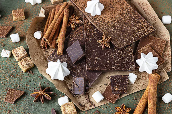Koyu ve sütlü çikolata parçaları, baharatlar, esmer şeker, krema ve marşmelov. Tatlı yemek fotoğraf konsepti.