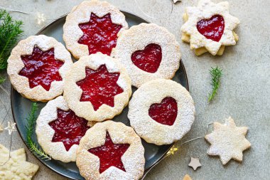Noel 'li tabak ya da kırmızı reçelli yeni yıl kurabiyesi. Geleneksel Avusturya kurabiyeleri ve reçel. Linzer kurabiyeleri. Taş arkaplan.