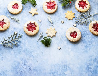 Linzer Noel ya da yeni yıl kurabiyeleri reçelle doldurulmuş ve mavi taş arka planda toz şekeri ile tozlanmış. Geleneksel Avusturya Noel kurabiyeleri. Şenlik dekorasyonu. Üst görünüm.