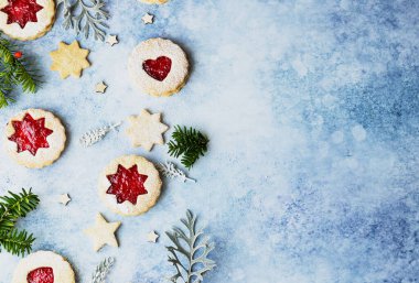 Linzer Noel ya da yeni yıl kurabiyeleri reçelle doldurulmuş ve mavi taş arka planda toz şekeri ile tozlanmış. Geleneksel Avusturya Noel kurabiyeleri. Şenlik dekorasyonu. Üst görünüm.