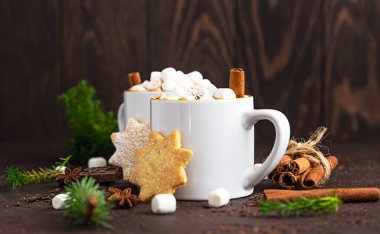 Marshmallow ve tarçınlı sıcak çikolata, kısa hamurlu kurabiyeler, baharatlar ve koyu taşlı arka planda acı çikolata. Şenlikli Noel ya da Yeni Yıl dekorasyonu.