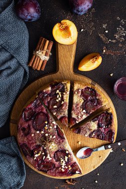 Ev yapımı erikli turta ya da ahşap tahtada fındık ve baharatlı kek, koyu kahverengi taş arka plan. Meyveli turta. Kırsal tarzda. Seçici odak.