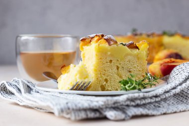 Muhallebi kremalı nefis şifon kek bitkisel çay ve açık beton arka planda kekik. Seçici odak.