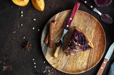 Ev yapımı erikli turta ya da ahşap tahtada fındık ve baharatlı kek, koyu kahverengi taş arka plan. Meyveli turta. Kırsal tarzda. Seçici odak.