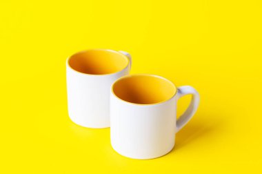 Boş kahve ya da sarı arka planda beyaz çay fincanı. Metin için alanı kopyala.