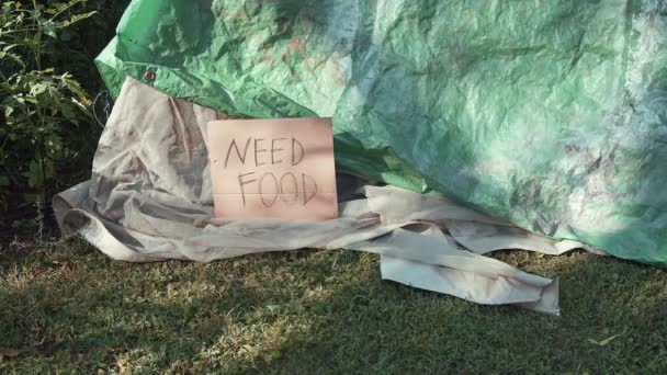 ホームレスのタープテントの隣に食べ物のサインが必要です — ストック動画