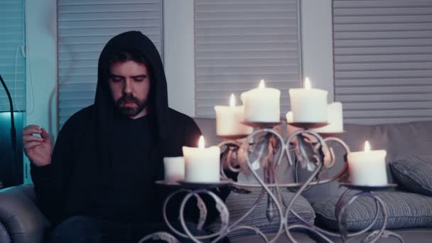Mann Meditiert Auf Couch Mit Kerze — Stockvideo