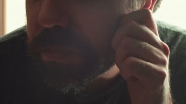 Aşırı büyümüş saçları olan dağınık bir adam.