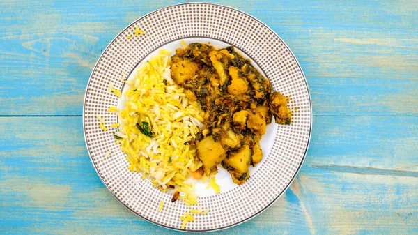 Вегетарианец в индийском стиле Алу Гоби Сааг с рисом — стоковое фото